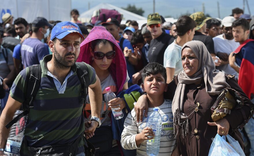Migrants pass the police cordon and board a train heading to the border with Serbia, near the town of Gevgelija.