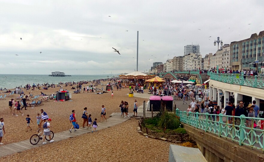 Despite cloudy weather, beaches are packed in Brighton, England. With airfares rising and the British pound down after the Brexit vote, some Britons are vacationing closer to home.