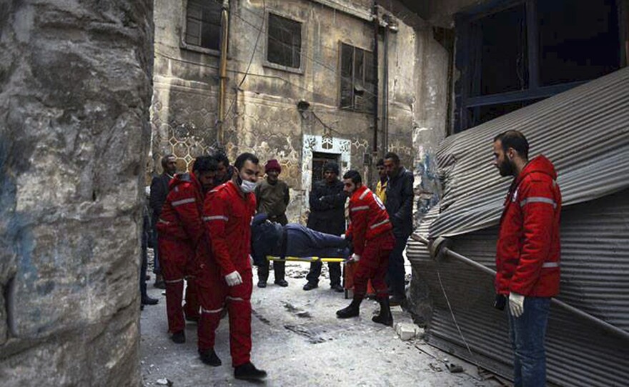 Members of the Syrian Arab Red Crescent carry a patient on a stretcher out of a medical facility in the Old City of Aleppo, Syria, on Wednesday.
