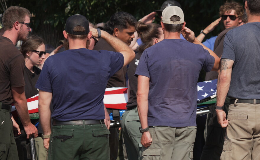 The body of a firefighter who died battling wildfires near the Colorado-Utah border is carried during a procession in Grand Junction, Colo., on June 29.