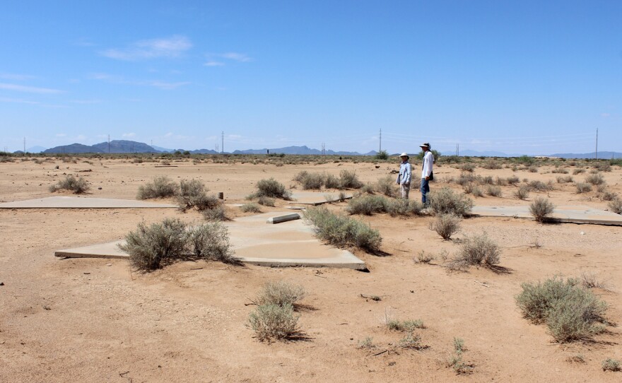Pez Owen and Chuck Penson inspect a concrete X in Casa Grande, Ariz. This marker is located just outside a rural neighborhood.