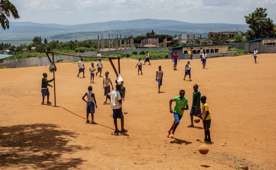 Students play near a genocide memorial site in Gahanga.