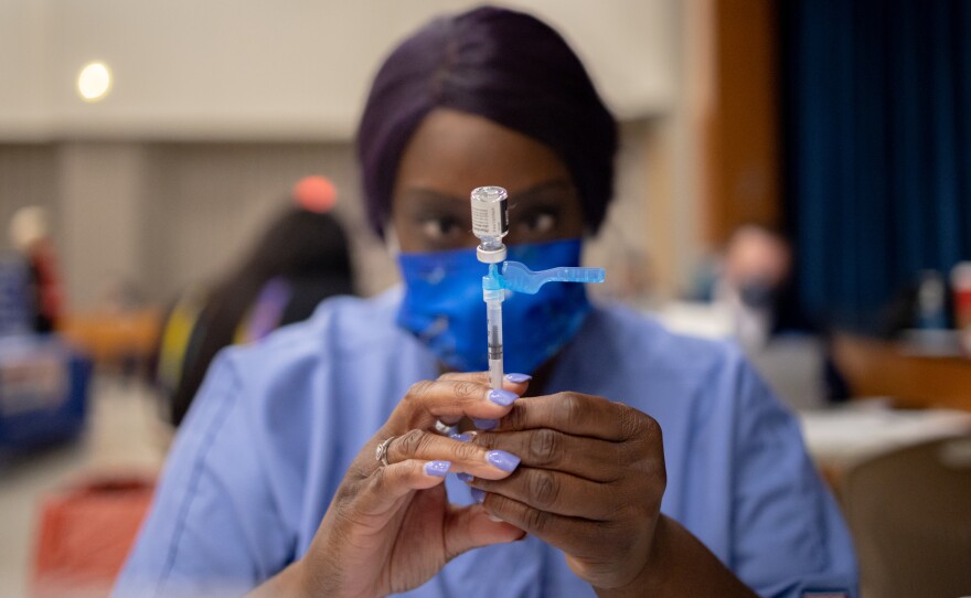 Dr. Anthony Fauci says he backs mandatory vaccines for teachers, citing a "critical situation" in the U.S. Here, a health care worker prepares a dose of the Pfizer-BioNTech COVID-19 vaccine at West Philadelphia High School in Philadelphia on Tuesday.