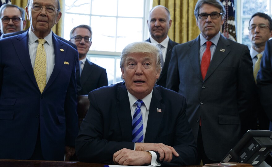 President Trump, flanked by Commerce Secretary Wilbur Ross (left) and Energy Secretary Rick Perry (right), announces the approval of a permit to build the Keystone XL pipeline, in March 2017.