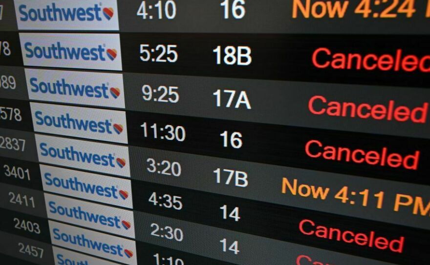 A digital display shows cancelled flights in the Southwest Airlines luggage area at Los Angeles International Airport in December 2022.