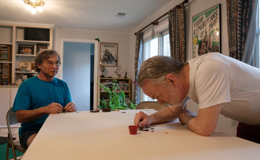 Larry Kahn (left) and Dave Lockwood practice tiddlywinks. The game has a startlingly simple premise for a game that draws an academic fandom.