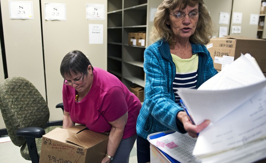 Document prep technician Carol Sine (left) and tracer Debra Barrett process firearm transaction documents at the National Tracing Center in Martinsburg, W.Va.