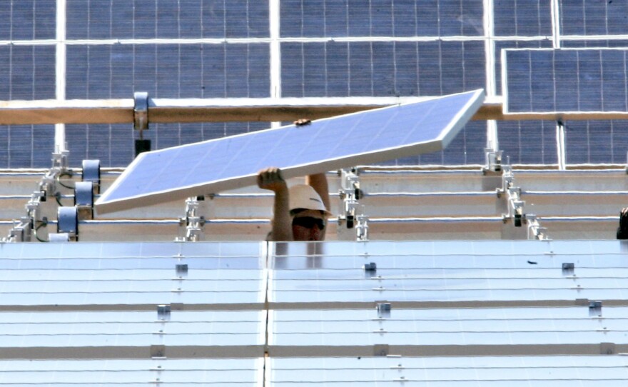 A solar energy panel is carried to be placed in a solar energy field at the Sacramento Municipal Utility District in Rancho Cordova, Calif.