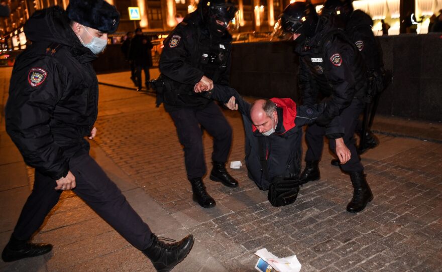Police officers detain a man during a protest in Moscow Thursday against Russia's invasion of Ukraine.