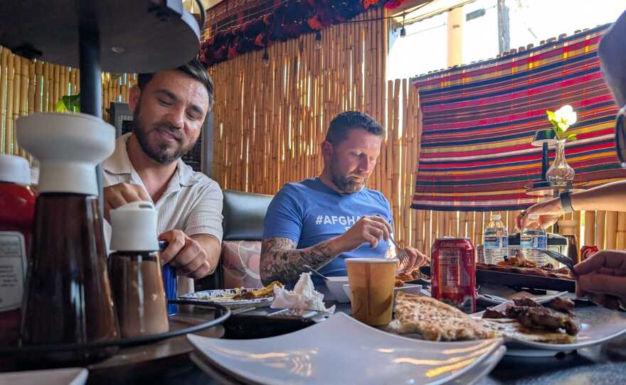 Sayed Naser, left, and Shawn VanDiver, right, eat lunch with friends and supporters in Lakeside Thursday in celebration of Naser's release from ICE detention. Oct. 2, 2025.