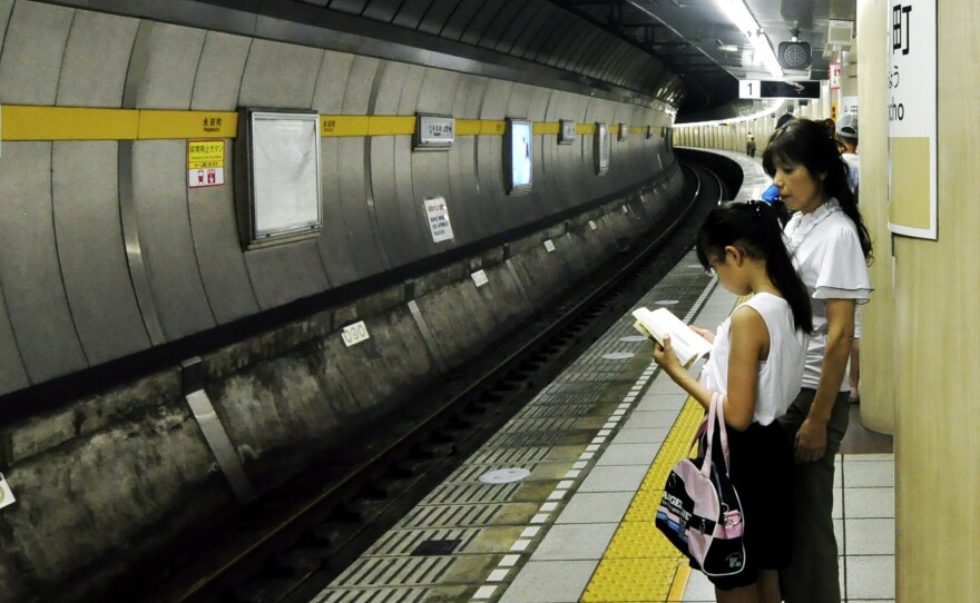 A child waits for the subway to arrive in Tokyo. Kids under 10 are often allowed to take the train by themselves.