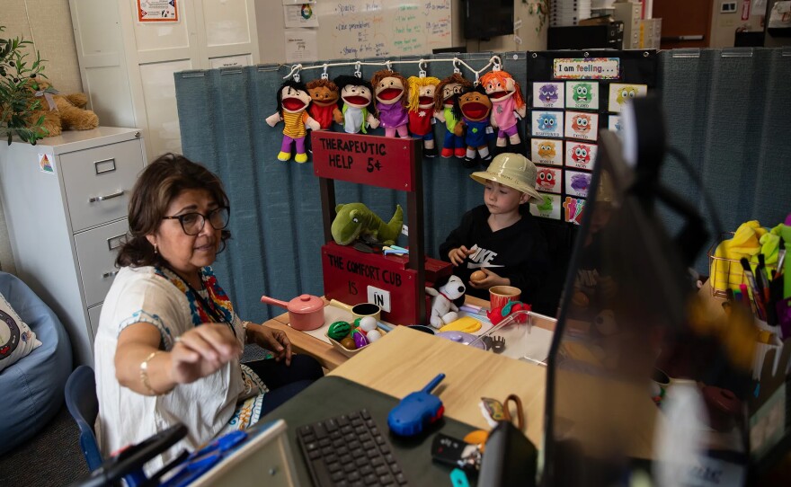 Clinical Supervisor Angelina Puffelis and a student play during a one-on-one therapy session at Mi Escuelita in San Diego on May 5, 2025. Since it can be difficult for children to express their emotions, Puffelis uses play therapy as a way to help her understand what a child might be experiencing. “It’s like being in a tour,” she said. “And for me, the child will be the tour guide. I will listen, I will follow, but if I have a question, I will probe and get information.”