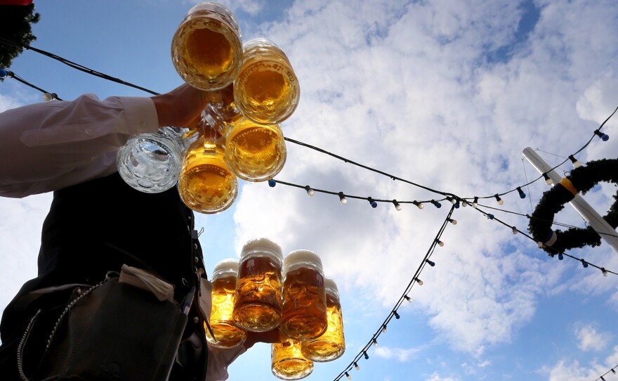A waiter carries beers at the Theresienwiese fair grounds of the Oktoberfest beer festival in Munich, southern Germany, last September. For centuries, a German law has stipulated that beer can only be made from four ingredients. But as Germany embraces craft beer, some believe the law impedes good brewing.