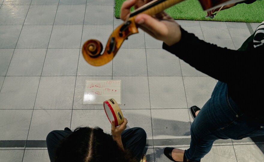 A juvenile detention center resident plays tambourine in collaboration with Sound Impact violinist <a href="http://www.annerdonaldson.com/">Anne Donaldson</a> during their final performance of the three-day "Use Your Voice" residency.