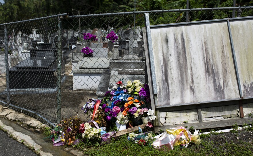 Friends and relatives of the dead leave flowers at the gates because they cannot enter the cemetery.
