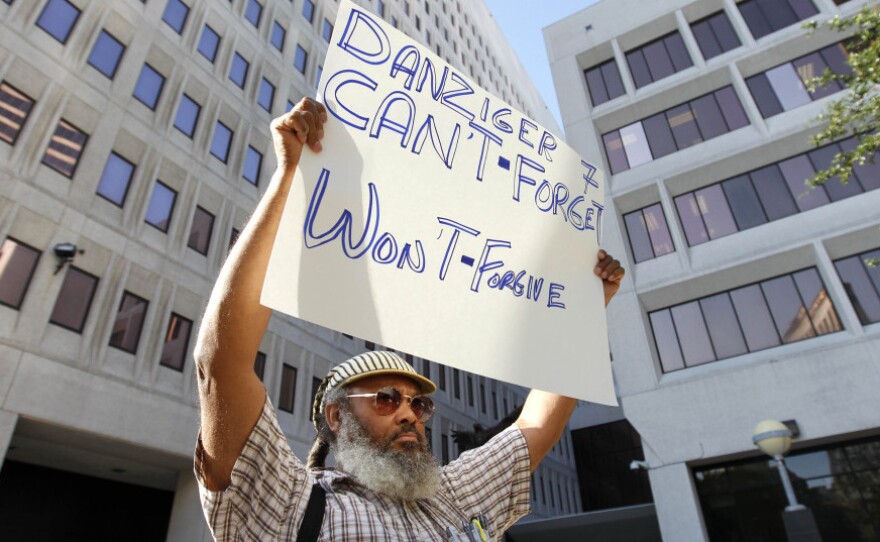 W.C. Johnson, of the group Community United for Change, protests outside federal court in New Orleans on the opening day of the Danziger trial in June. On Aug. 5, five police officers were convicted of various roles in gunning down  innocent civilians in the days after Hurricane Katrina and then  covering it up. Five other officers pleaded guilty.