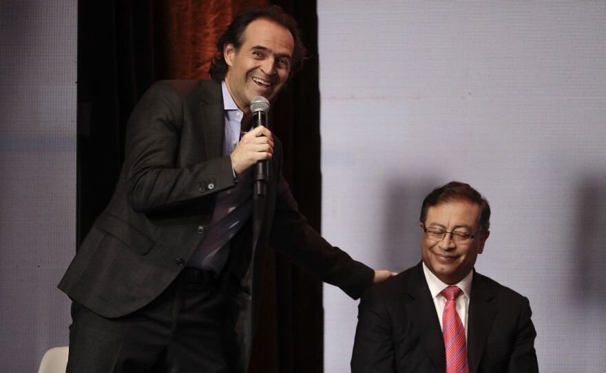 Federico Gutiérrez, a candidate with the Team for Colombia coalition, touches the shoulder of Gustavo Petro, candidate with the Historic Pact coalition, during a debate in Bogotá, Colombia, Jan. 25.