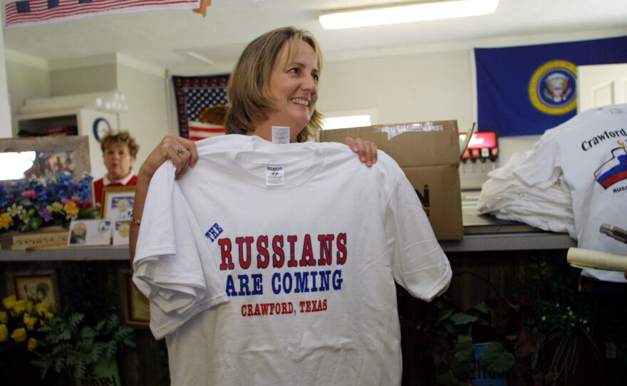 A woman holds up a T-shirt that says "The Russians are Coming" at The Brown Bag gift shop in anticipation of Putin's visit to Crawford, Texas.