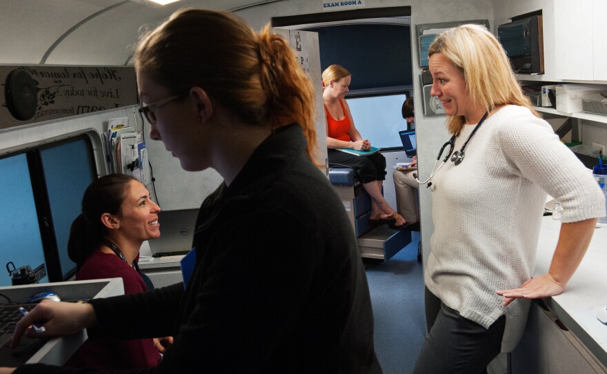 Physician assistants and undergraduate care coordinators treat patients in the mobile clinic parked at Majestic Oaks, a low-income apartment complex in Gainesville.