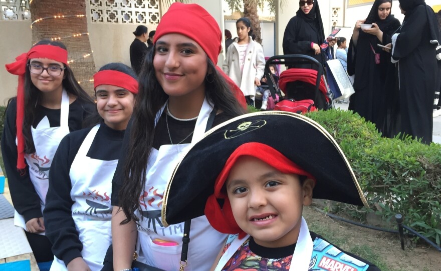 Nouf al-Mazrou, with the red head scarf in the center, runs a barbeque catering business from her home in the Saudi capital Riyadh. She's shown here at a gathering of Saudi women who have launched businesses on Instagram. The event was held at a private girls school.