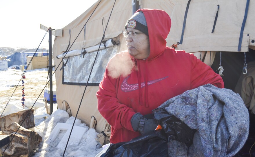 Dotty Agard of the Standing Rock Sioux tribe sorts through abandoned goods at camp. Tribal members and several hundred protesters are assisting with the cleanup.