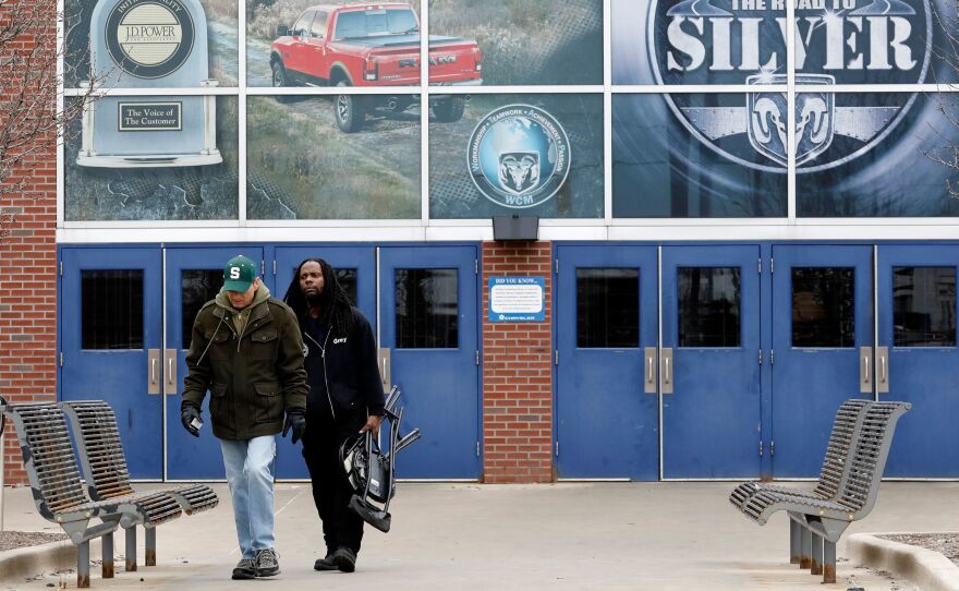 Workers leave an FCA Chrysler truck plant in Detroit on March 18 after the automaker shut down all of its North America factories as a precaution against the coronavirus.