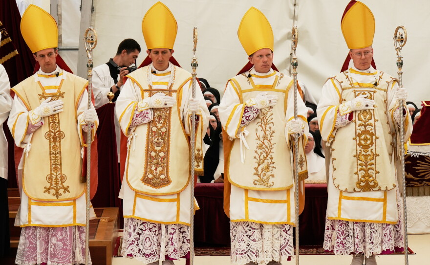 Newly consecrated Bishops, from left, Marc Hanappier, Michel Poinsinet de Sivry, Michael Goldade and Pascal Schreiber wearing their miters and holding their pastoral staffs, stand at the end of their consecration ceremony in a tent set up outside the Society of St. Pius X seminary in Econe, Switzerland, Wednesday, July 1, 2026.