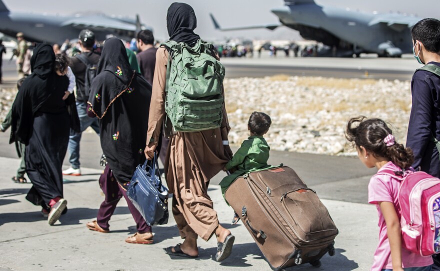 Families walk toward their flight during evacuations at Hamid Karzai International Airport in Kabul, Afghanistan, on Tuesday.