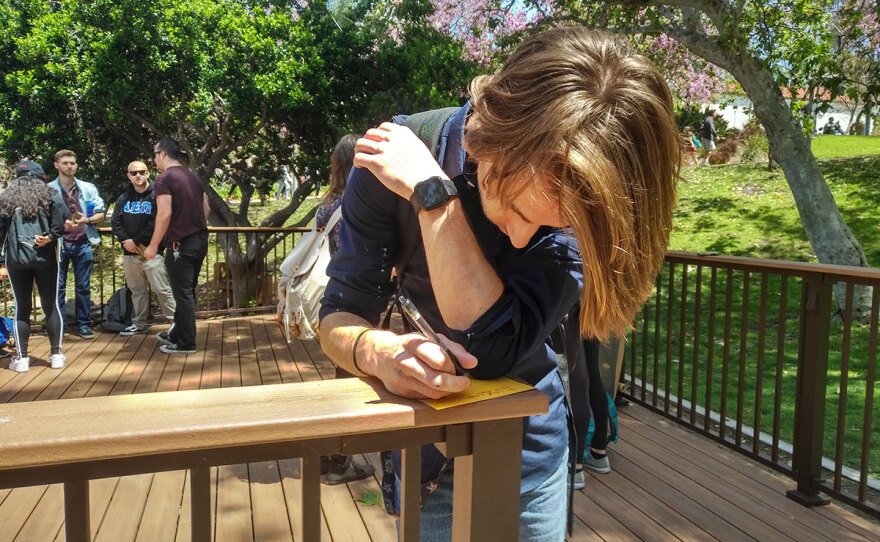 Marshall Cotta writes a note of condolence to the congregants of Chabad of Poway at San Diego State University's National Holocaust Remembrance Day vigil on May 1, 2019.