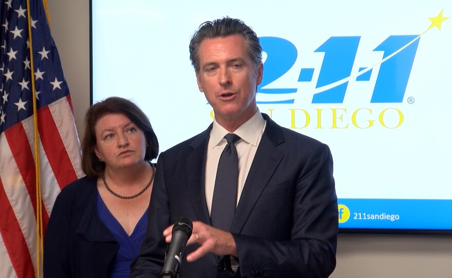 Governor Gavin Newsom speaks at 211 San Diego, while standing in front of state Senator Toni Atkins on Friday August 9, 2019.