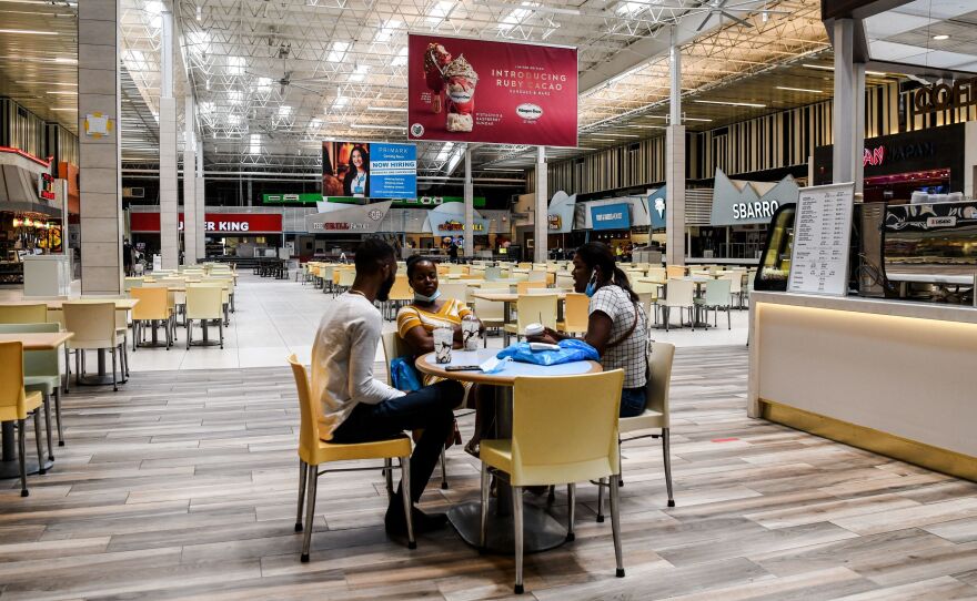 People eat in a deserted food court inside a mall west of Fort Lauderdale, Fla., Monday. U.S. states have been easing restrictions on businesses ahead of Memorial Day, the traditional start of the summer vacation and outdoor season.