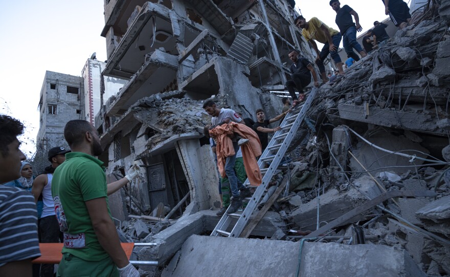 Palestinians rescue a young girl from the rubble of a destroyed residential building following an Israeli airstrike on Tuesday.
