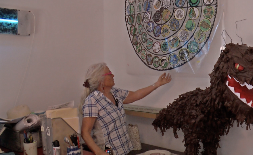 Artist Robin Brailsford gestures toward the design of an upcoming LithoMosaic she and her partner, Wick Alexander, are working on for the Lincoln City Cultural Center in Lincoln City, Oregon, Aug. 28, 2023.