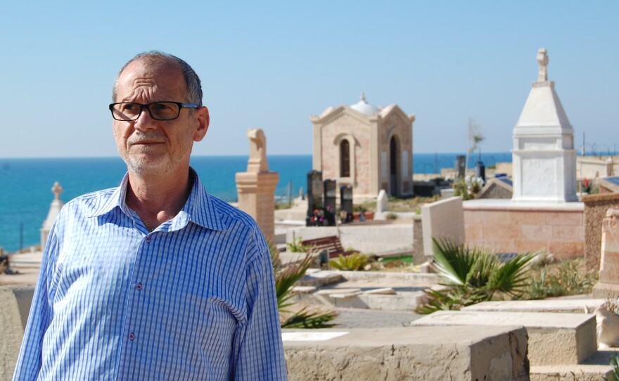 Peter Habash, an Arab Christian, stands at a Christian graveyard in Jaffa. "We have no connection" with migrant or Russian Christians, he says.