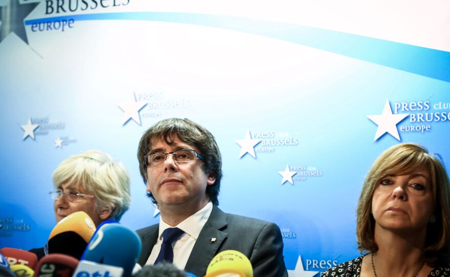 Catalonia's deposed leader, Carles Puigdemont (center), speaks at a news conference in Brussels on Tuesday with other members of his dismissed government.
