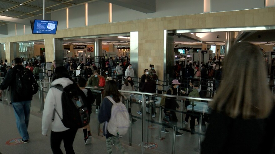 Passengers stand in line at the Terminal 2 TSA checkpoint at San Diego International Airport on Dec. 21, 2021.