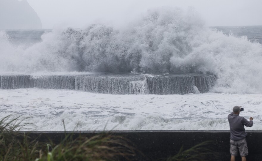 A man takes pictures of huge waves in Yilan as Typhoon Haikui makes landfall in eastern Taiwan on Sunday, Sept. 3, 2023.