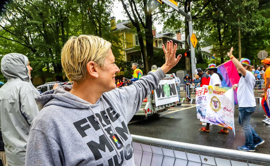 Sara waving at marchers during Atlanta Pride