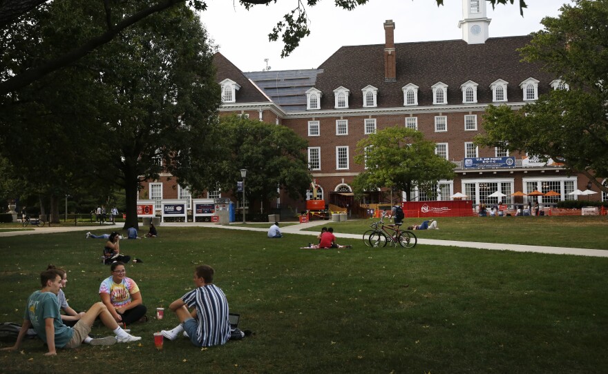 Students chat on a lawn this fall at the University of Illinois at Urbana-Champaign. It's unclear how disruptions to campus life during the pandemic might affect student voter turnout on Election Day.