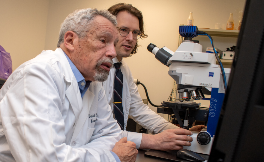 Dr. Dan Perl, professor of Pathology at USU, left, and Dr. David Priemer, assistant professor of Pathology at USU, led a new study that suggests chronic traumatic encephalopathy, or CTE, is uncommon in service members.