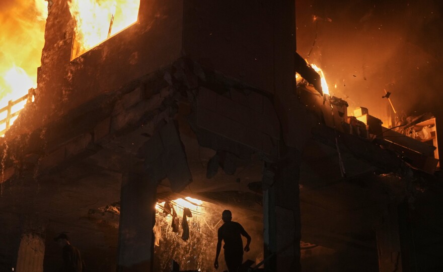 Palestinians react to a fire following an Israeli strike on a residential building in the Rimal neighborhood of Gaza City, Friday, May 15, 2026.