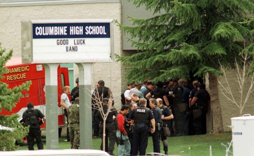 Police gather at the east entrance of Columbine High School in Littleton, Colo., on April 20, 1999. School security has improved markedly since the Columbine shooting, experts say, but there still are problems.