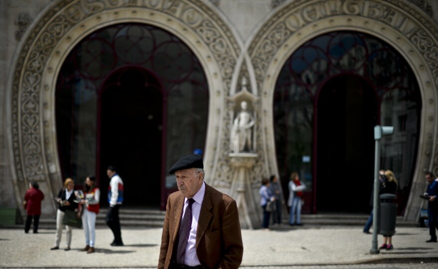 A man passes in front of Rossio train station in 2014 (when King Sebastian still stood watch).