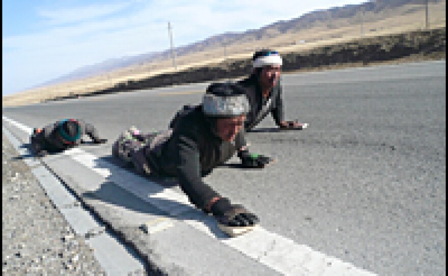 Pilgrims prostrate themselves along a highway near Qinghai Lake. These young Tibetan men say they have no Chinese friends.