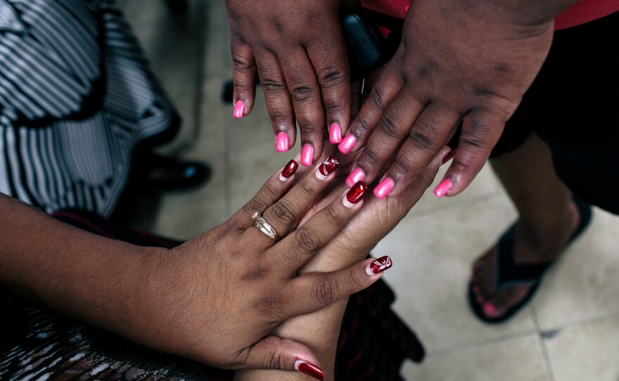 Ruby Corado looks at the freshly-painted nails of Lazema Mills, 30, at Casa Ruby. Mills lives in one of the transitional group homes Corado has opened in D.C.