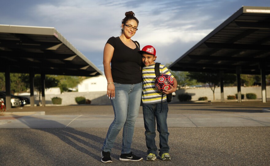 Humberto and his mother, Zaira Yanez, pose for a portrait outside his school. Not knowing english, she says, sometimes keeps her from helping Humberto more.