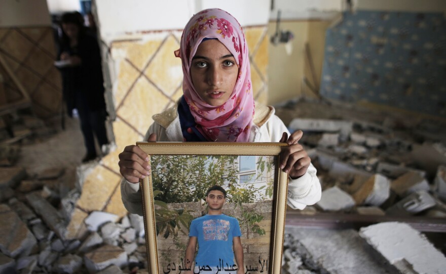 A relative of Shaludi displays his portrait inside his family home after it was razed by Israeli authorities.