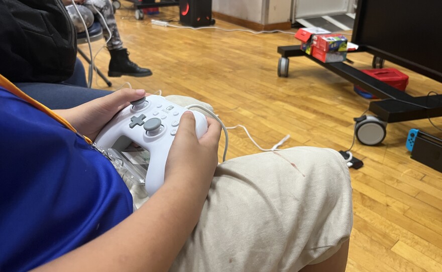 An elementary school student holds a video game controller, Dec. 8, 2025.