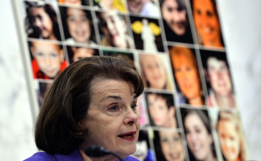 Pictures of the Sandy Hook Elementary School shooting victims are displayed as Sen. Dianne Feinstein (D-Calif.) speaks during at a 2013 Senate hearing. Wednesday's shooting in San Bernardino, which killed at least 14 people, was the deadliest since the 2012 shooting at Sandy Hook, which left 26 people dead.