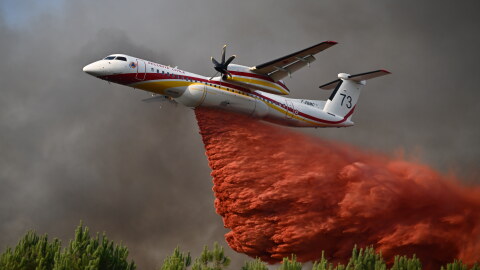 A plane releases fire retardant as it flies over a forest near Blagon, during wildfires in southwestern France, July 29, 2026.